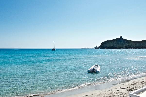 Ein Boot am Strand vor dem Almar Timi Ama Resort & Spa mit blauem Himmel und Wasser