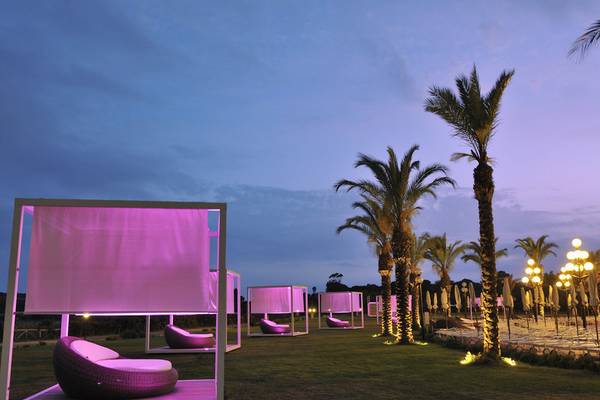 Nachtlandschaft mit pink beleuchteten Betten und Palmen im Almar Timi Ama Resort & Spa