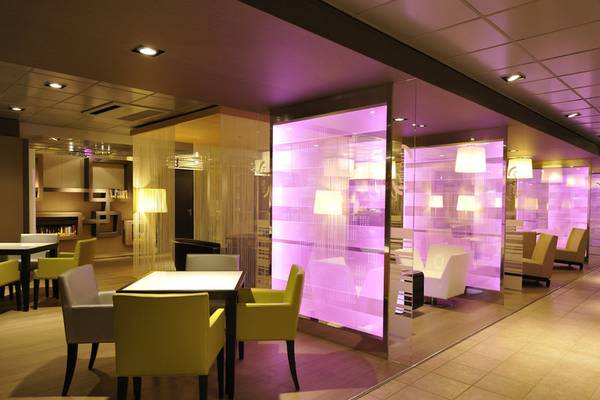 Loungebereich im Almar Timi Ama Resort & Spa mit violetten Wänden und modernen Möbeln.
