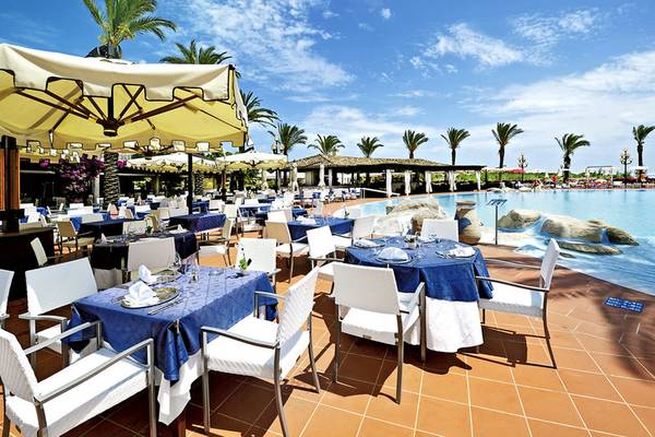 Pool-Restaurant des Almar Timi Ama Resort & Spa mit blauen Tischdecken und Sonnenschirmen.