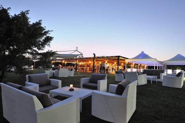 Außenbereich des Almar Timi Ama Resort & Spa bei Abend mit beleuchteten Tischen und Stühlen.