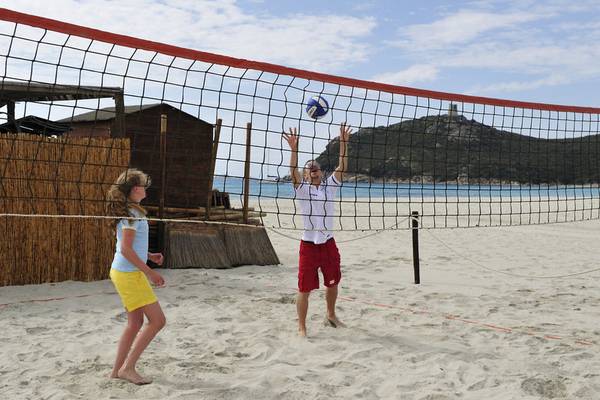 Ein Junge und ein Mädchen spielen Volleyball am Strand des Almar Timi Ama Resort & Spa.