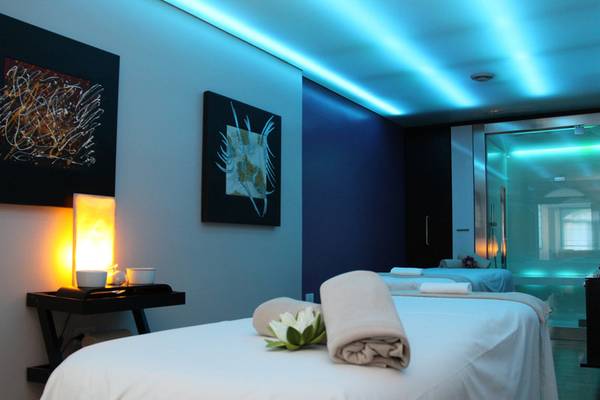 Behandlungsraum im Almar Timi Ama Resort & Spa mit Massagebett, Blumendekor und Ambientebeleuchtung