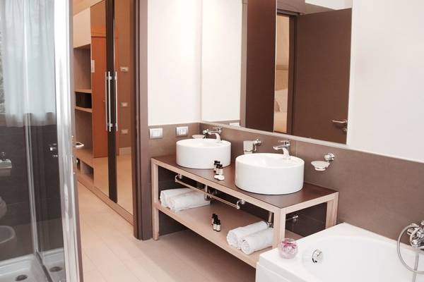Badezimmer im Almar Timi Ama Resort & Spa mit zwei Waschbecken, Badewanne und Dusche.