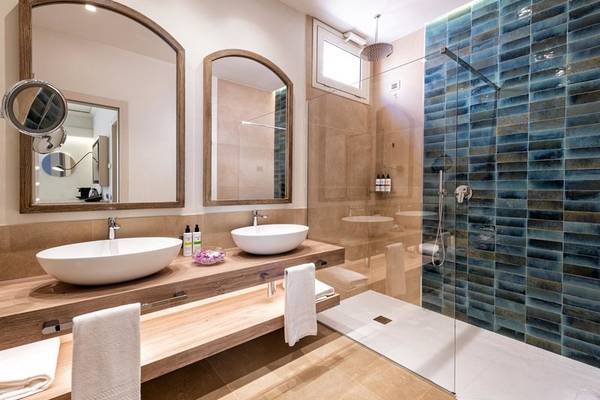 Badezimmer im Almar Timi Ama Resort & Spa mit zwei Waschbecken und blauen Kacheln.