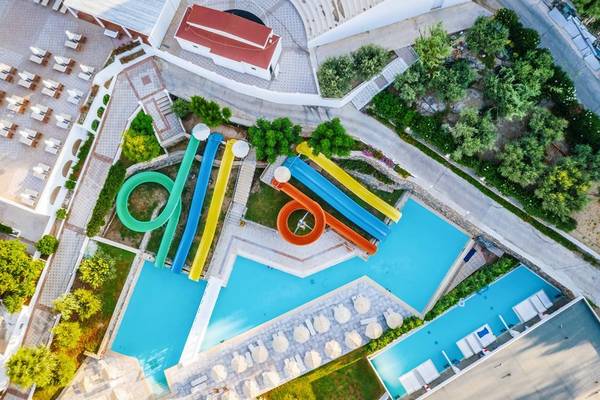 Luftaufnahme des Schwimmbads im Lindos Royal Resort mit mehreren Wasserrutschen und Sonnenliegen.