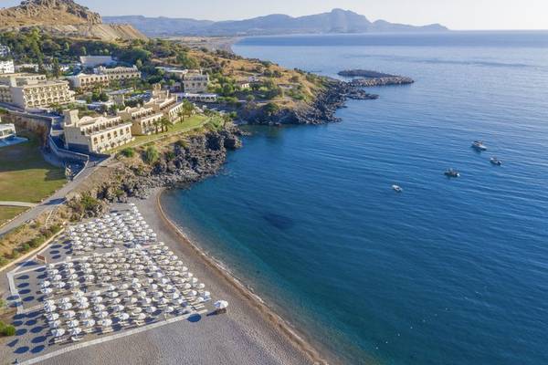 Luftaufnahme des Lindos Royal Resorts mit Strand, vielen Sonnenschirmen und Booten im Meer.