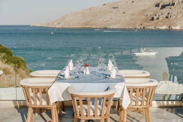 Tisch im Lindos Royal Resort mit Blick auf das Meer und eine Insel.