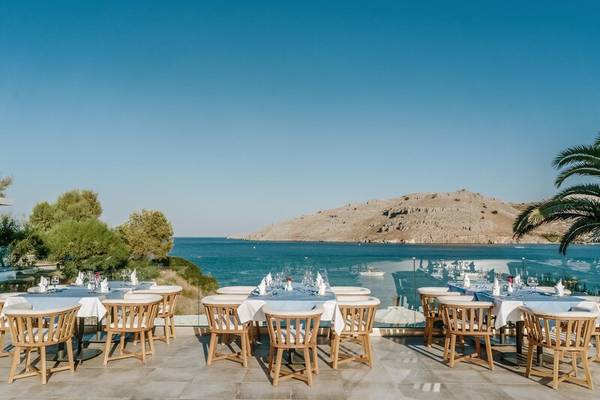 Terrasse des Lindos Royal Resorts mit Blick auf das Meer und eine Insel.