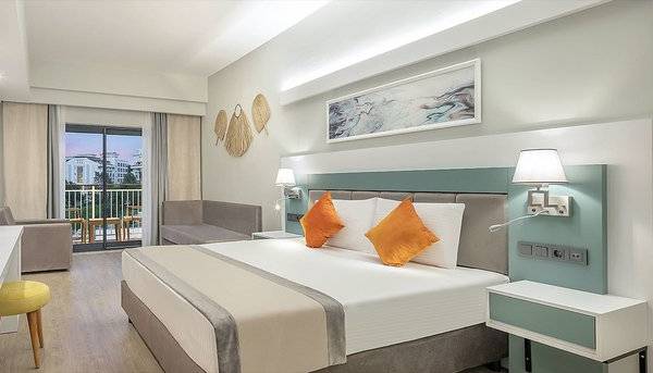 Ein modernes Hotelzimmer von Arcanus Hotels Trendline Side mit einem Bett, Fernseher, Schreibtisch und Balkon.