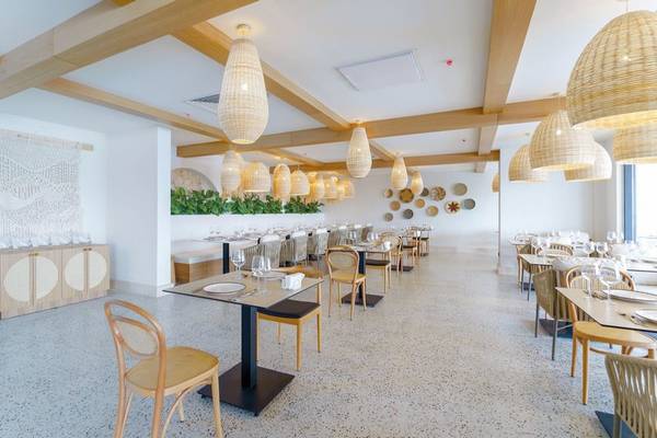 Innenansicht des Restaurants im Arcanus Hotels Trendline Side mit heller Einrichtung, Holzmöbeln und Korblampen.