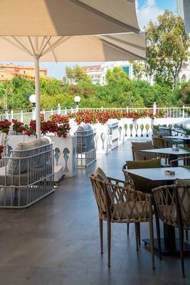 Terrasse des Arcanus Hotels Trendline Side mit Tischen, Stühlen und Sonnenschirmen.