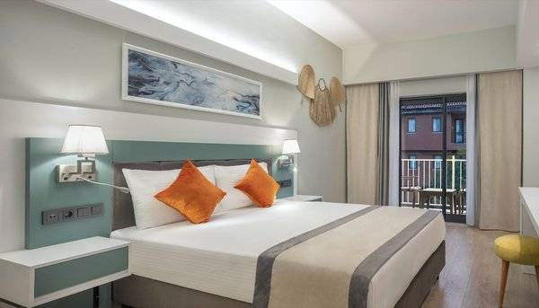 Hotelzimmer im Arcanus Hotels Trendline Side mit Bett, Fernseher, Schreibtisch und Balkon.