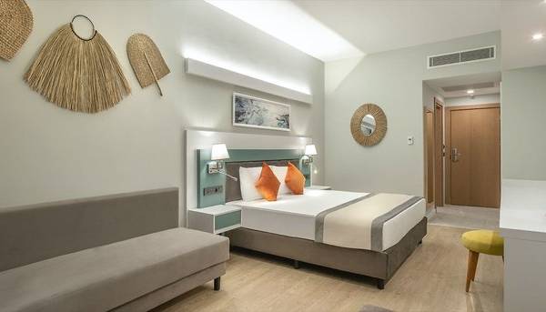 Ein modernes Hotelzimmer von Arcanus Hotels Trendline Side mit einem Bett, Sofa, Schreibtisch und Dekor.