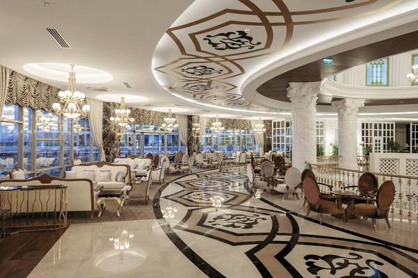 Innenansicht der Lobby im Sunis Efes Royal Palace Resort & Spa mit eleganten Möbeln und Kronleuchtern.