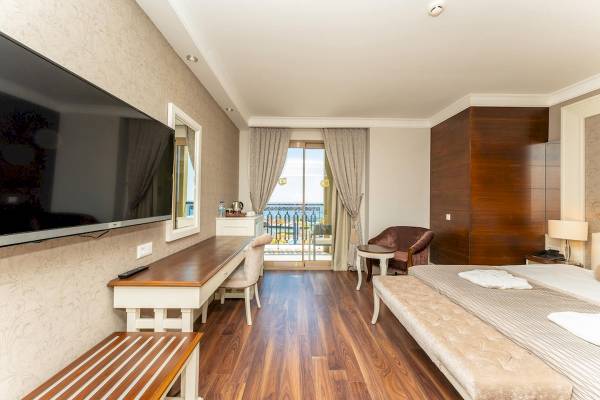 Innenansicht eines eleganten Hotelzimmers im Sunis Efes Royal Palace Resort & Spa mit Blick auf den Hafen.