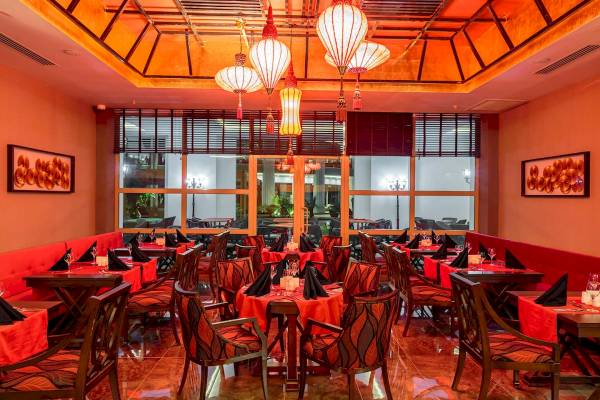 Innenansicht des Restaurants im Sunis Efes Royal Palace Resort & Spa mit roten Tischen und Stühlen.