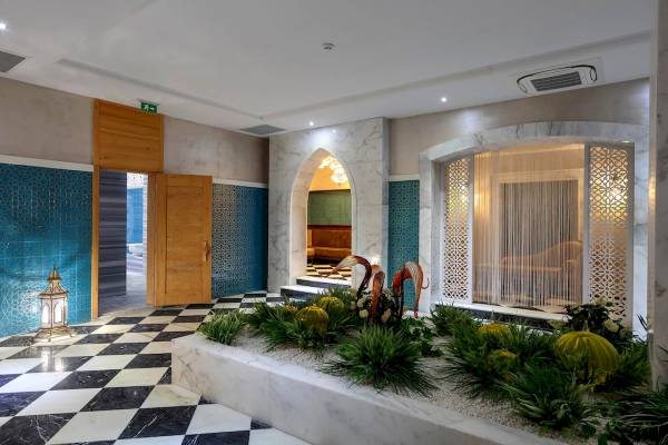 Eingangsbereich des Sunis Efes Royal Palace Resort & Spa mit blauen und weißen Wandmustern und einem schwarzen Schachbrettboden.