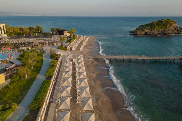 Luftaufnahme des Sunis Efes Royal Palace Resorts mit Blick auf den Strand, Meer und eine Insel.