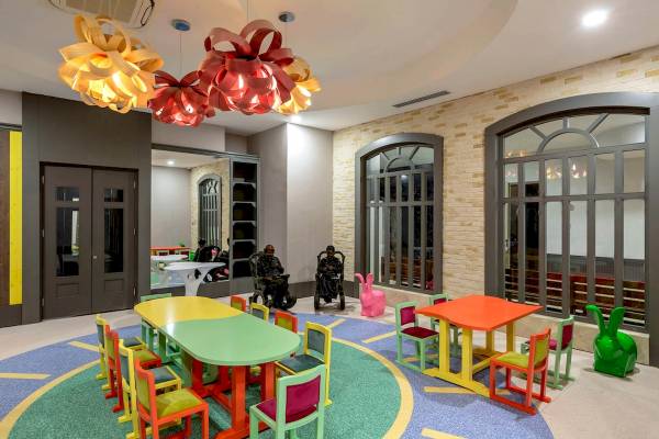 Spielzimmer im Sunis Efes Royal Palace Resort & Spa mit bunten Tischen, Stühlen und Kaninchenskulpturen.