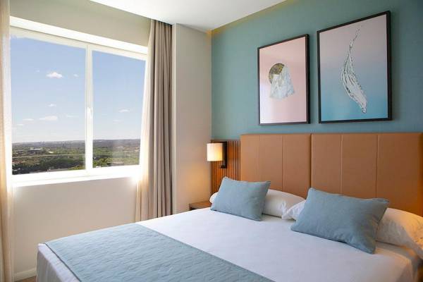 Ein Zimmer im Riu Plaza Espana Hotel mit einem Bett, Fenster und Aussicht auf eine Stadt.