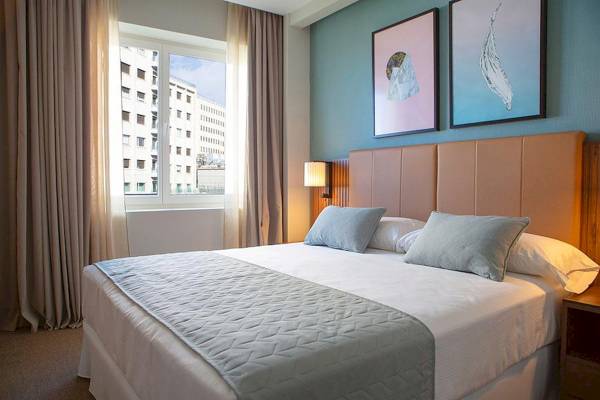 Hotelzimmer im Riu Plaza Espana mit Doppelbett, Fenster und blauer Wand.