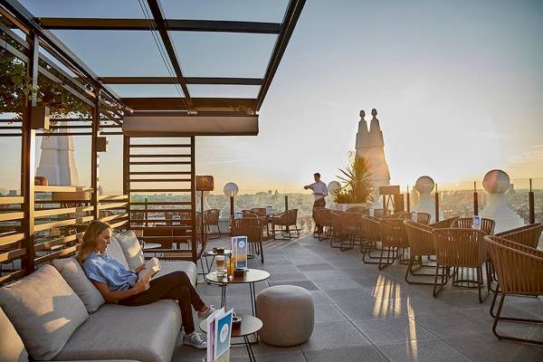 Frau auf der Terrasse des Riu Plaza Espana liest ein Buch bei Sonnenuntergang.