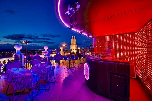 Bar-Terrasse im Riu Plaza Espana Hotel bei Nacht mit lila Beleuchtung und roter Wand