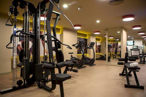 Fitnessstudio im Riu Plaza Espana Hotel mit verschiedenen Geräten und Trainingsbereichen.