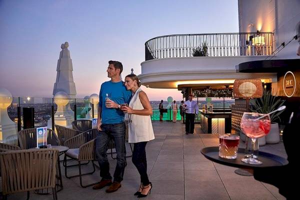 Paar auf der Terrasse des Riu Plaza Espana mit Cocktails.