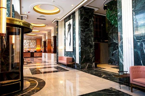 Foyer des Riu Plaza Espana Hotels mit schwarzen und weißen Marmorboden und Möbeln.