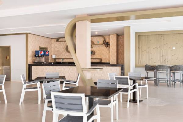 Innenraum des Pickalbatros Aqua Blu Resort in Hurghada mit Tischen, Stühlen und einer Theke.