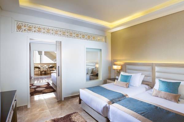 Doppelzimmer im Pickalbatros Aqua Blu Resort in Hurghada mit zwei Betten, Nachttischen und einem Fernseher.