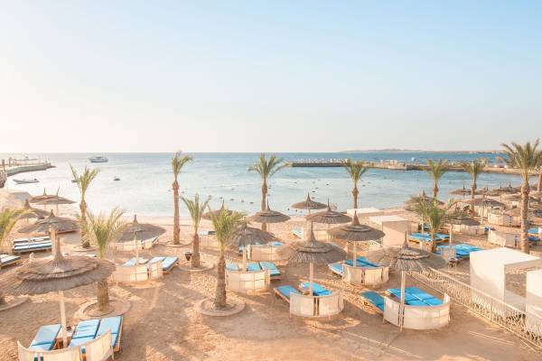 Pickalbatros Aqua Blu Resort in Hurghada mit Strand, Sonnenschirmen und Liegen.