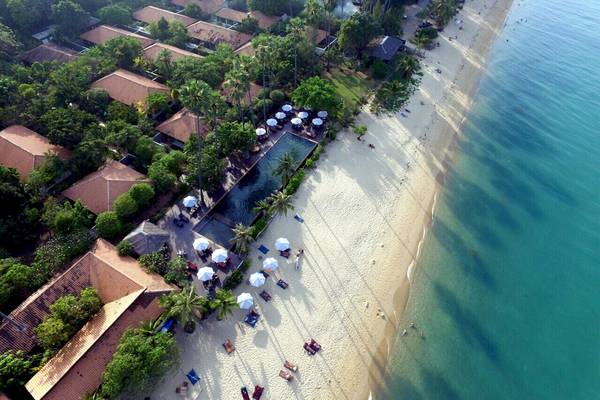 Luftaufnahme des Saree Samui Resorts mit vielen Gebäuden, Swimmingpool, vielen Gästen, Palmen und weißem Sandstrand.