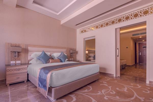 Schlafzimmer im Pickalbatros Aqua Blu Resort in Hurghada mit einem Doppelbett und Nachttischen.