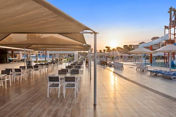 Außenbereich des Pickalbatros Aqua Blu Resort in Hurghada mit vielen Tischen und Stühlen und einem Pool