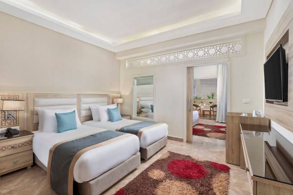 Doppelzimmer im Pickalbatros Aqua Blu Resort in Hurghada mit zwei Betten, Dekor und Fernseher.