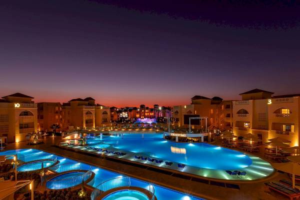 Abendansicht des Pickalbatros Aqua Blu Resorts in Hurghada mit beleuchtetem Pool und Loungebereich.