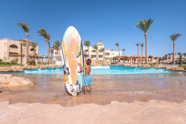 Junge am Pickalbatros Aqua Blu Resort in Hurghada am Pool mit Surfbrett
