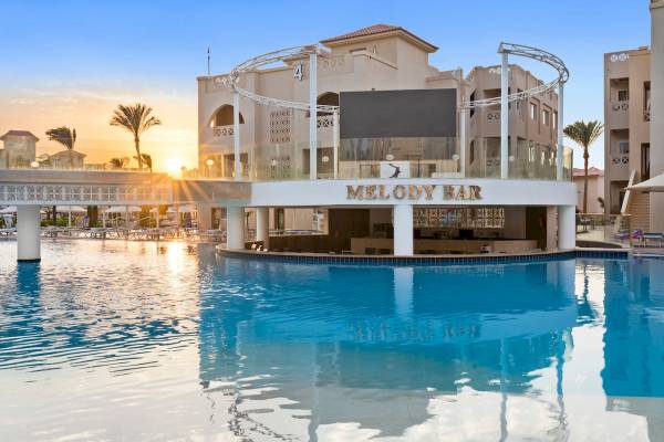 Außenansicht des Pickalbatros Aqua Blu Resorts in Hurghada mit dem Melody Bar-Poolbereich bei Sonnenuntergang.