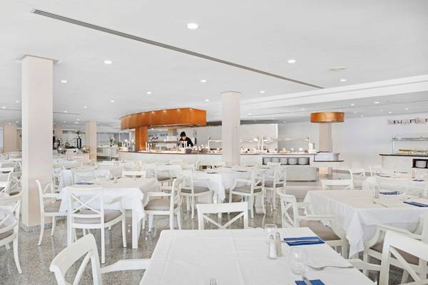 Innenansicht des Restaurants im ALUA Gran Camp de Mar Hotel mit weißen Tischen und Stühlen.
