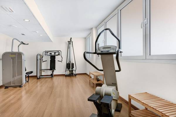 Fitnessbereich im Hotel ALUA Gran Camp de Mar mit Laufband, Gewichtsbank und Rudergerät.