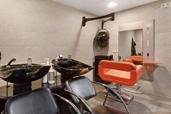 Friseursalon im ALUA Gran Camp de Mar mit modernen Stühlen und Waschbecken.