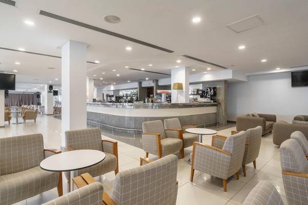 Lobby des ALUA Gran Camp de Mar Hotels mit Sitzgelegenheiten und einer Theke.