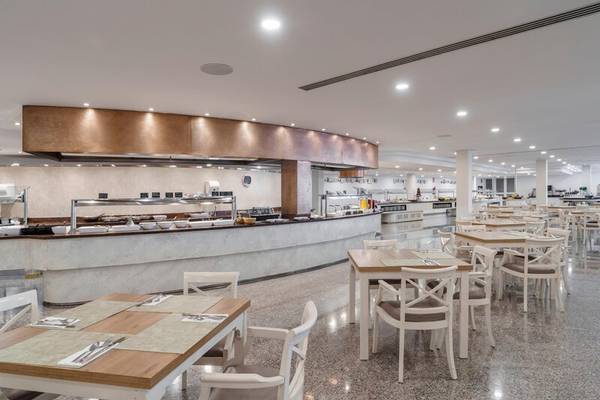 Innenansicht des Restaurants im ALUA Gran Camp de Mar Hotel mit einer langen Theke und runden Tischen.