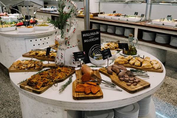 Buffettisch im Hotel ALUA Gran Camp de Mar mit verschiedenen Gerichten und einer beschrifteten Tafel.