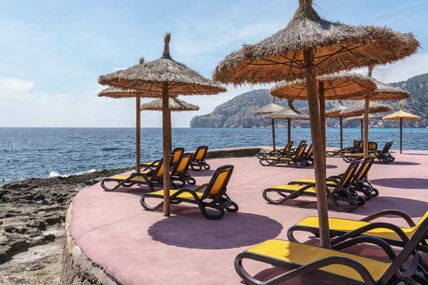 Liegen und Strohschirme am Strand des ALUA Gran Camp de Mar Hotels
