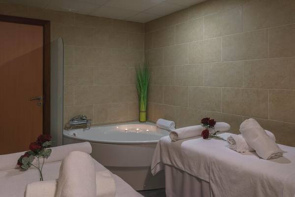 Spa-Behandlungsraum im ALUA Gran Camp de Mar mit einem Whirlpool und zwei Massagetischen.
