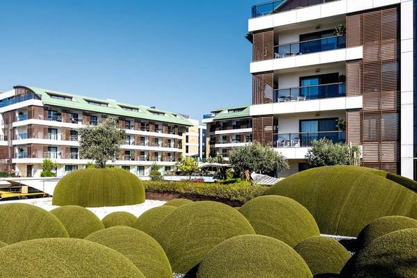 Außenansicht des TUI BLUE Side Hotels mit geformten Hecken und modernen Gebäuden.